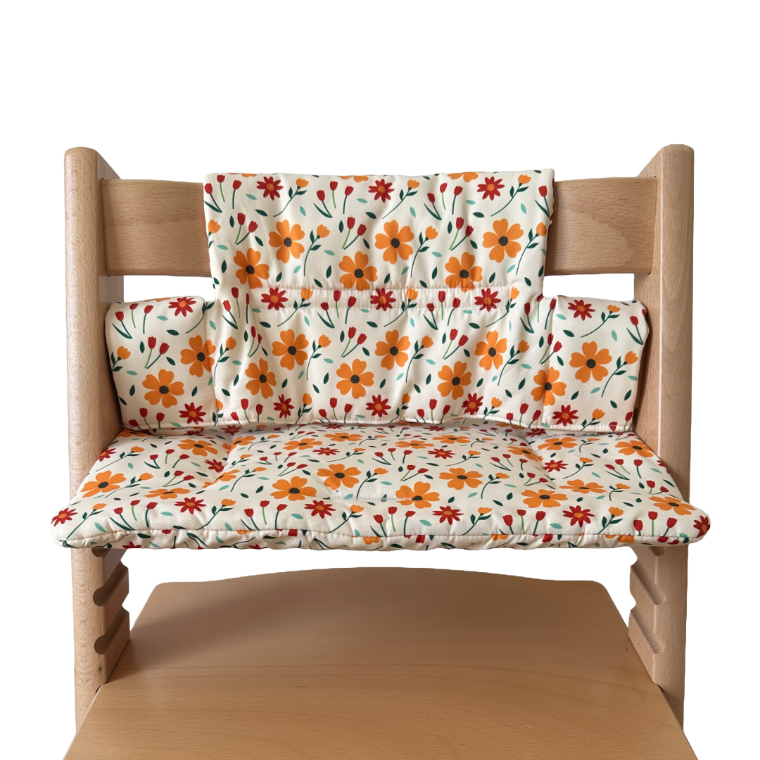 Kussenset voor Stokke Tripp Trapp met bloemenprint (oranje, rood). Vooraanzicht van het kussen op de stoel zonder gebruik van de babyset.
