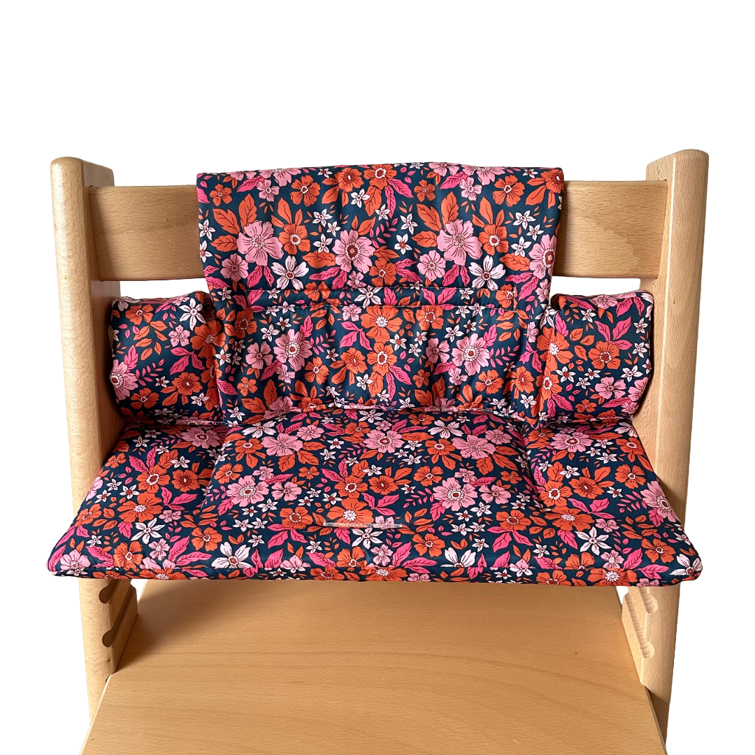 Kussenset voor Stokke Tripp Trapp met bloemenprint (oranje, roze). Vooraanzicht van het kussen op de stoel zonder gebruik van de babyset.