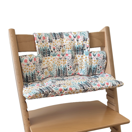 Kussenset voor Stokke Tripp Trapp met print bloemenweide (blauw). Zijaanzicht van het kussen op de stoel zonder gebruik van de babyset.