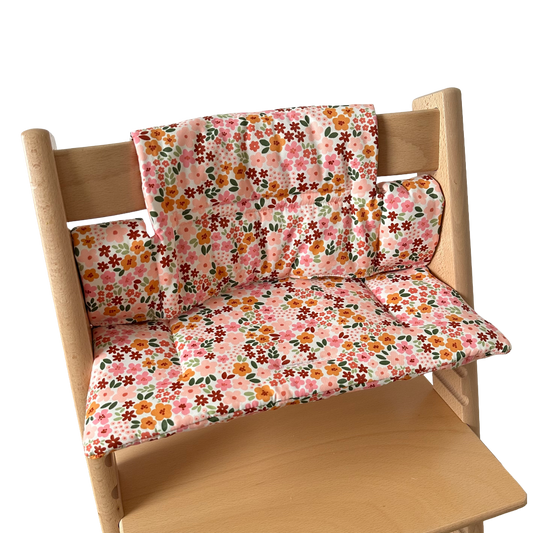 Kussenset voor Stokke Tripp Trapp met herfstbloemen (oranje, rood, roze). Zijaanzicht van het kussen op de stoel zonder gebruik van de babyset.