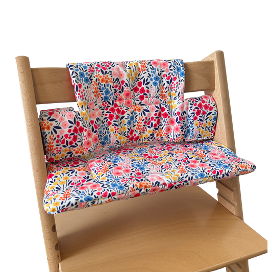Kussenset voor Stokke Tripp Trapp met kleurrijke bloemen. Zijaanzicht van het kussen op de stoel zonder gebruik van de babyset.