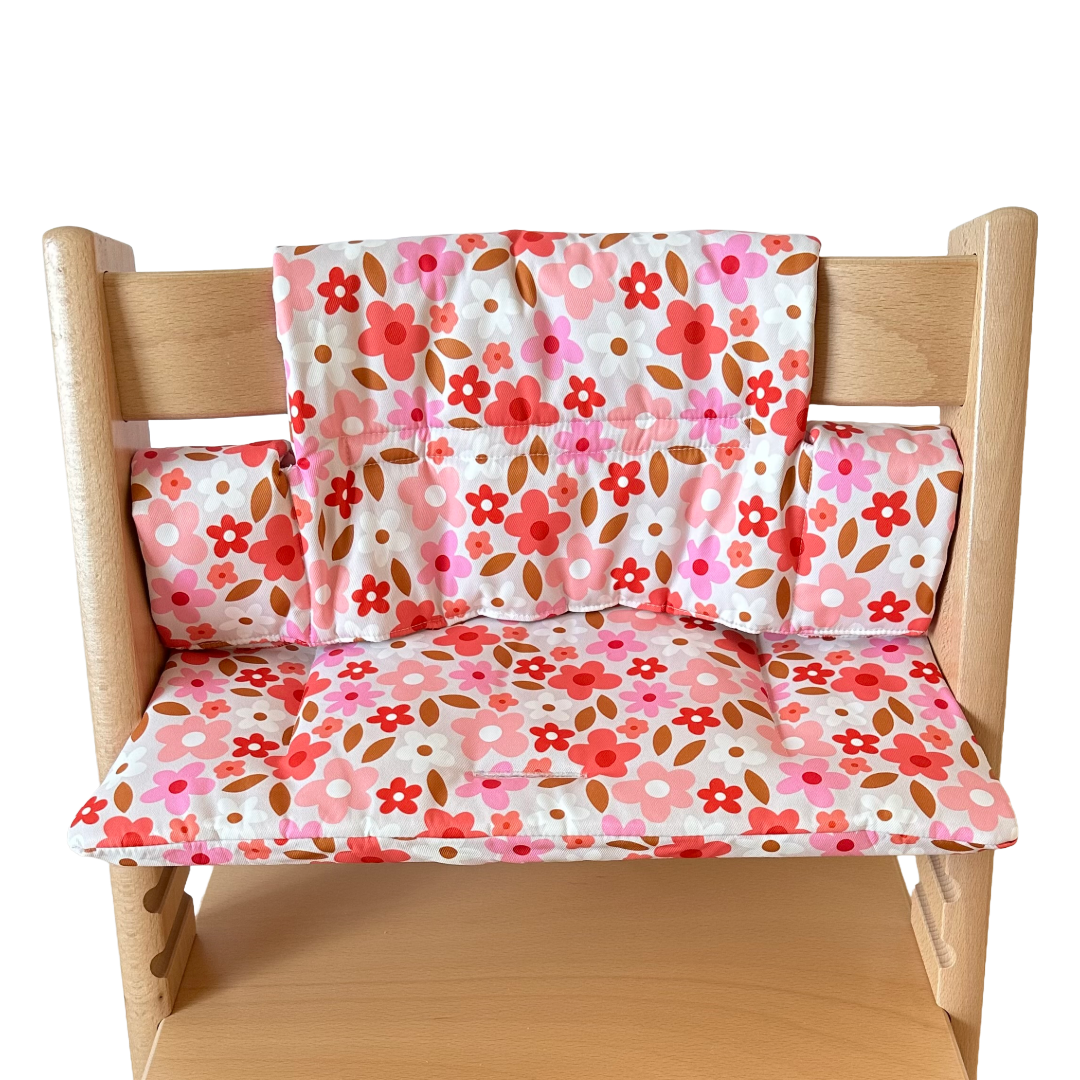 Kussenset voor Stokke Tripp Trapp met print madeliefjes (roze, rood, wit). Vooraanzicht van het kussen op de stoel zonder gebruik van de babyset.