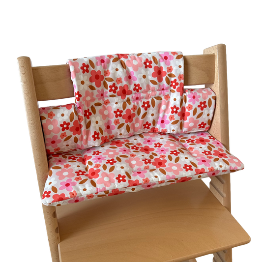 Kussenset voor Stokke Tripp Trapp met print madeliefjes (roze, rood, wit). Zijaanzicht van het kussen op de stoel zonder gebruik van de babyset.