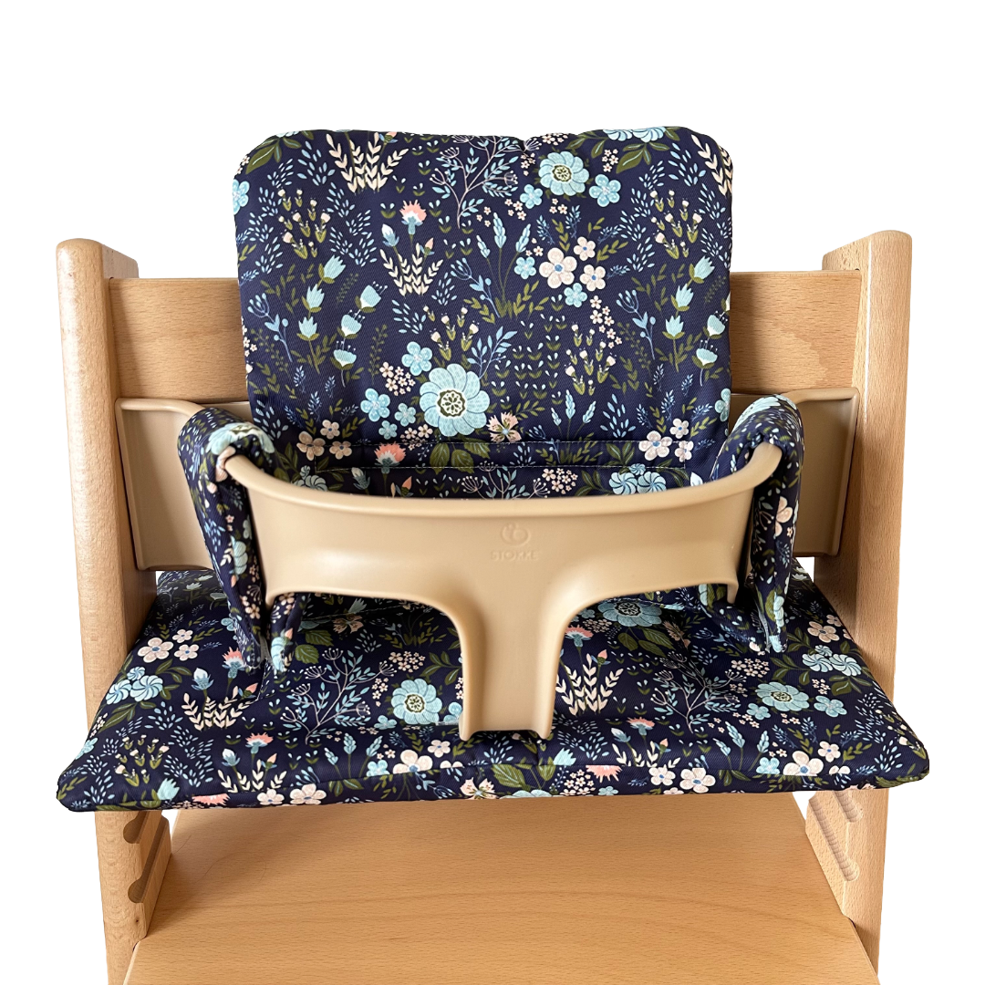 Kussenset voor Stokke Tripp Trapp met bloemenprint (blauw). Vooraanzicht van het kussen op de stoel met gebruik van de babyset.