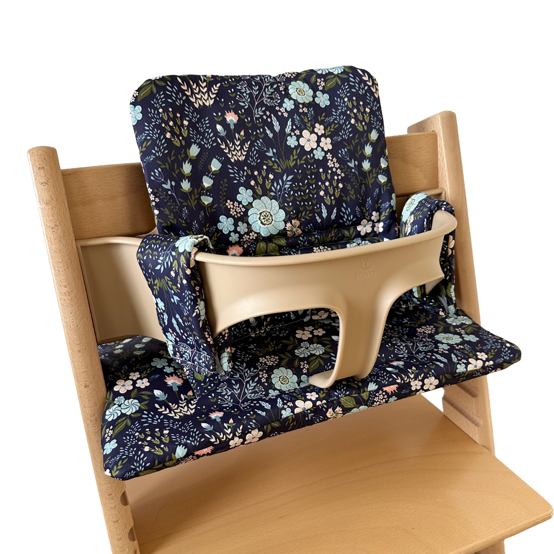 Kussenset voor Stokke Tripp Trapp met bloemenprint (blauw). Zijaanzicht van het kussen op de stoel met gebruik van de babyset.