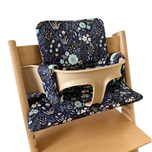 Kussenset voor Stokke Tripp Trapp met bloemenprint (blauw). Zijaanzicht van het kussen op de stoel met gebruik van de babyset.