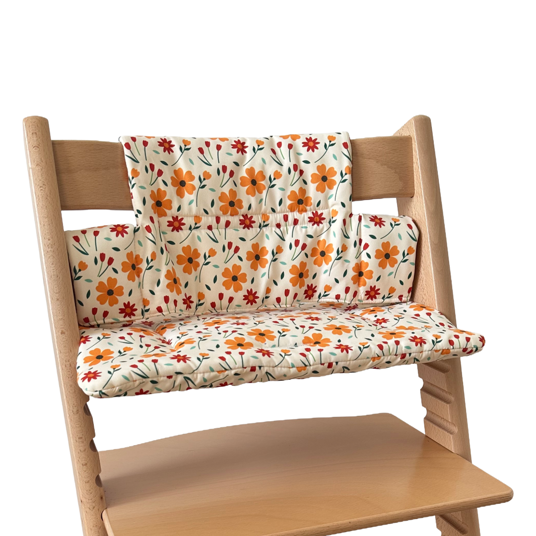 Kussenset voor Stokke Tripp Trapp met bloemenprint (oranje, rood). Zijaanzicht van het kussen op de stoel zonder gebruik van de babyset.