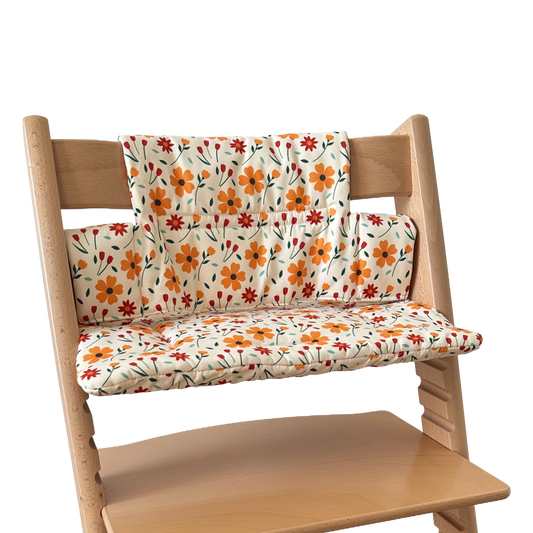 Kussenset voor Stokke Tripp Trapp met bloemenprint (oranje, rood). Zijaanzicht van het kussen op de stoel zonder gebruik van de babyset.