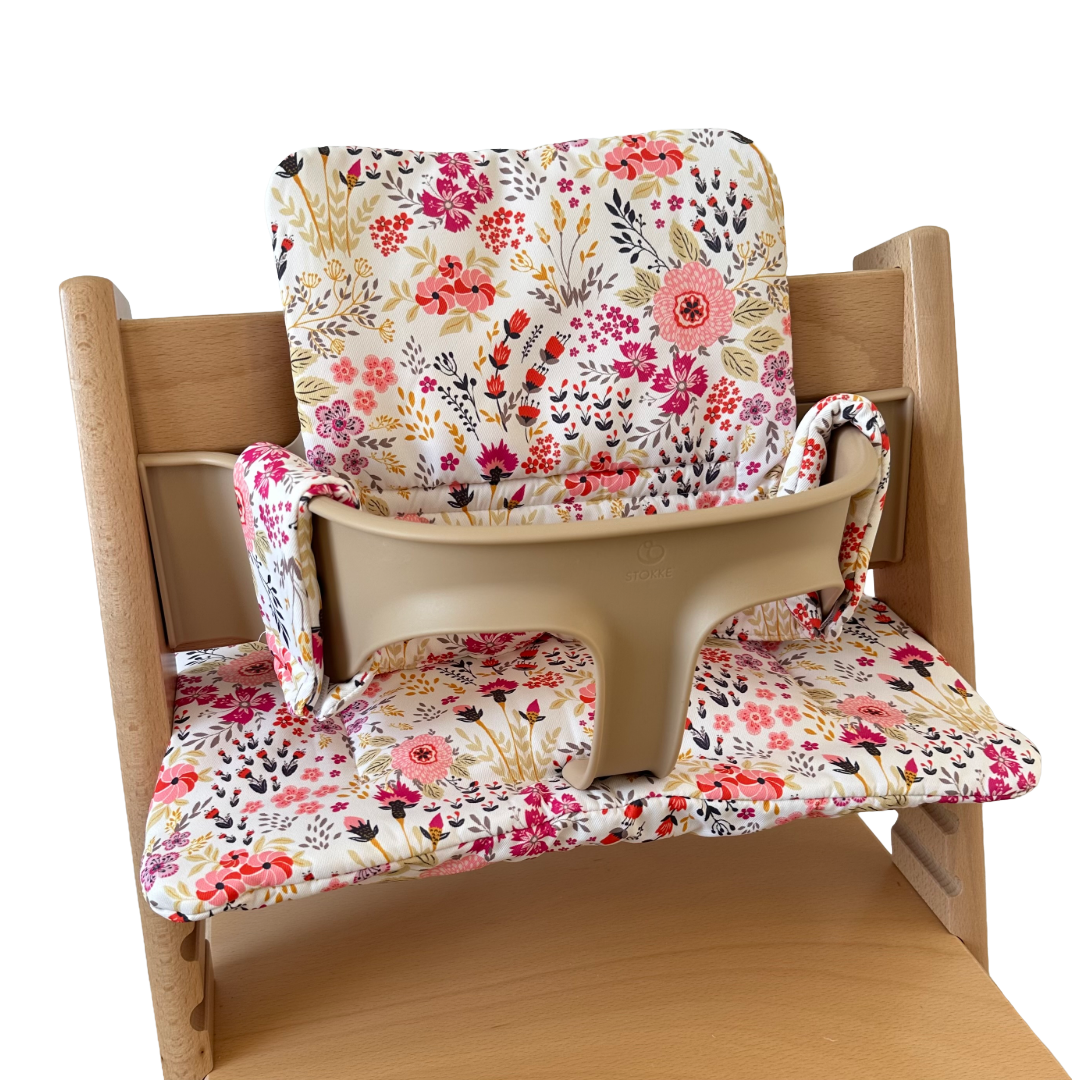 Kussenset voor Stokke Tripp Trapp met bloemenprint (roze). Zijaanzicht van het kussen op de stoel met gebruik van de babyset.