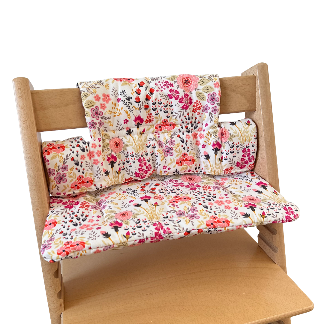 Kussenset voor Stokke Tripp Trapp met bloemenprint (roze). Zijaanzicht van het kussen op de stoel zonder gebruik van de babyset.