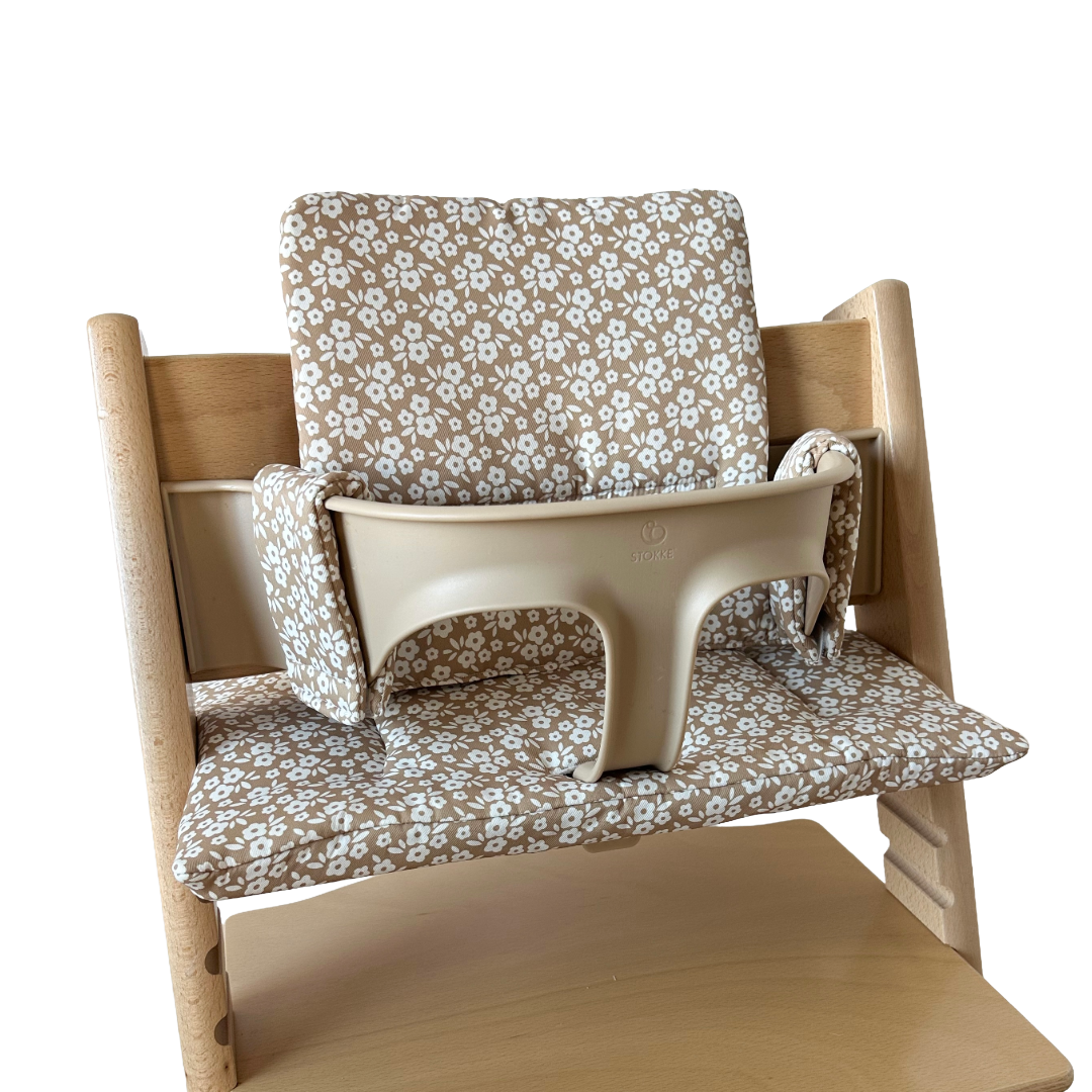 Kussenset voor Stokke Tripp Trapp met minimalistische bloemenprint (bruin, creme). Zijaanzicht van het kussen op de stoel met gebruik van de babyset.