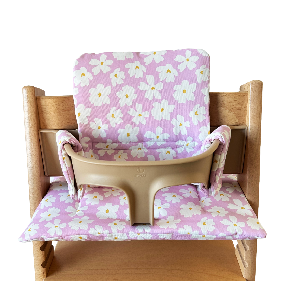 Kussenset voor Stokke Tripp Trapp met bloemenprint (roze, wit). Vooraanzicht van het kussen op de stoel met gebruik van de babyset.