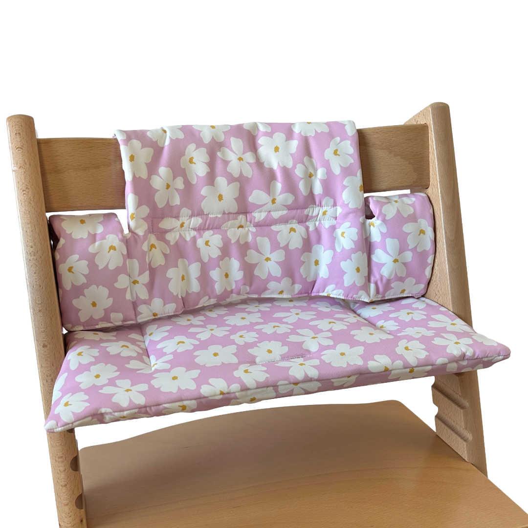 Kussenset voor Stokke Tripp Trapp met bloemenprint (roze, wit). Zijaanzicht van het kussen op de stoel zonder gebruik van de babyset.