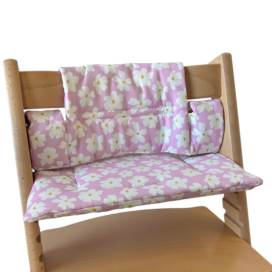 Kussenset voor Stokke Tripp Trapp met bloemenprint (roze, wit). Zijaanzicht van het kussen op de stoel zonder gebruik van de babyset.