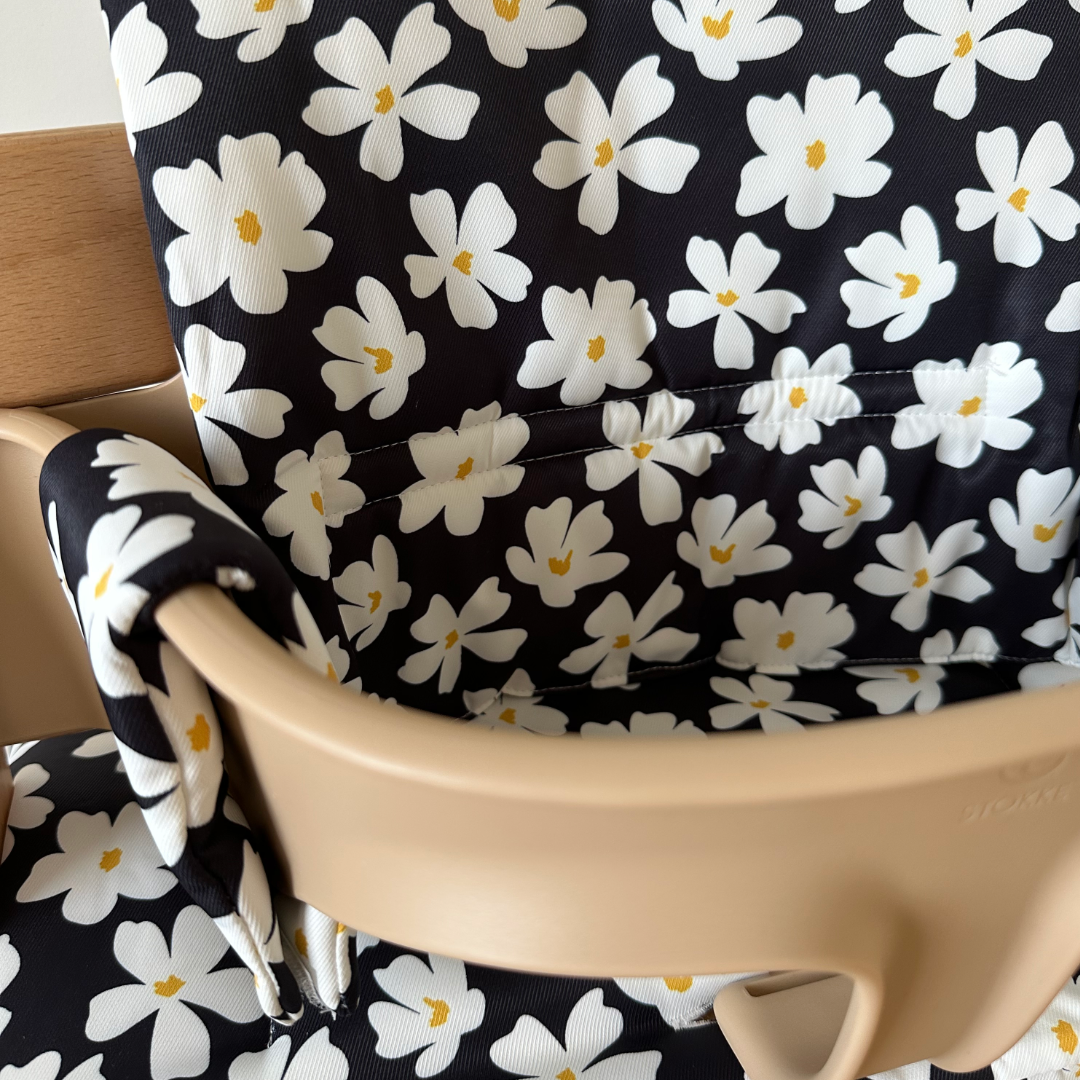 Kussenset voor Stokke Tripp Trapp met bloemenprint (zwart, wit). Close up van het kussen op de stoel met gebruik van de babyset.