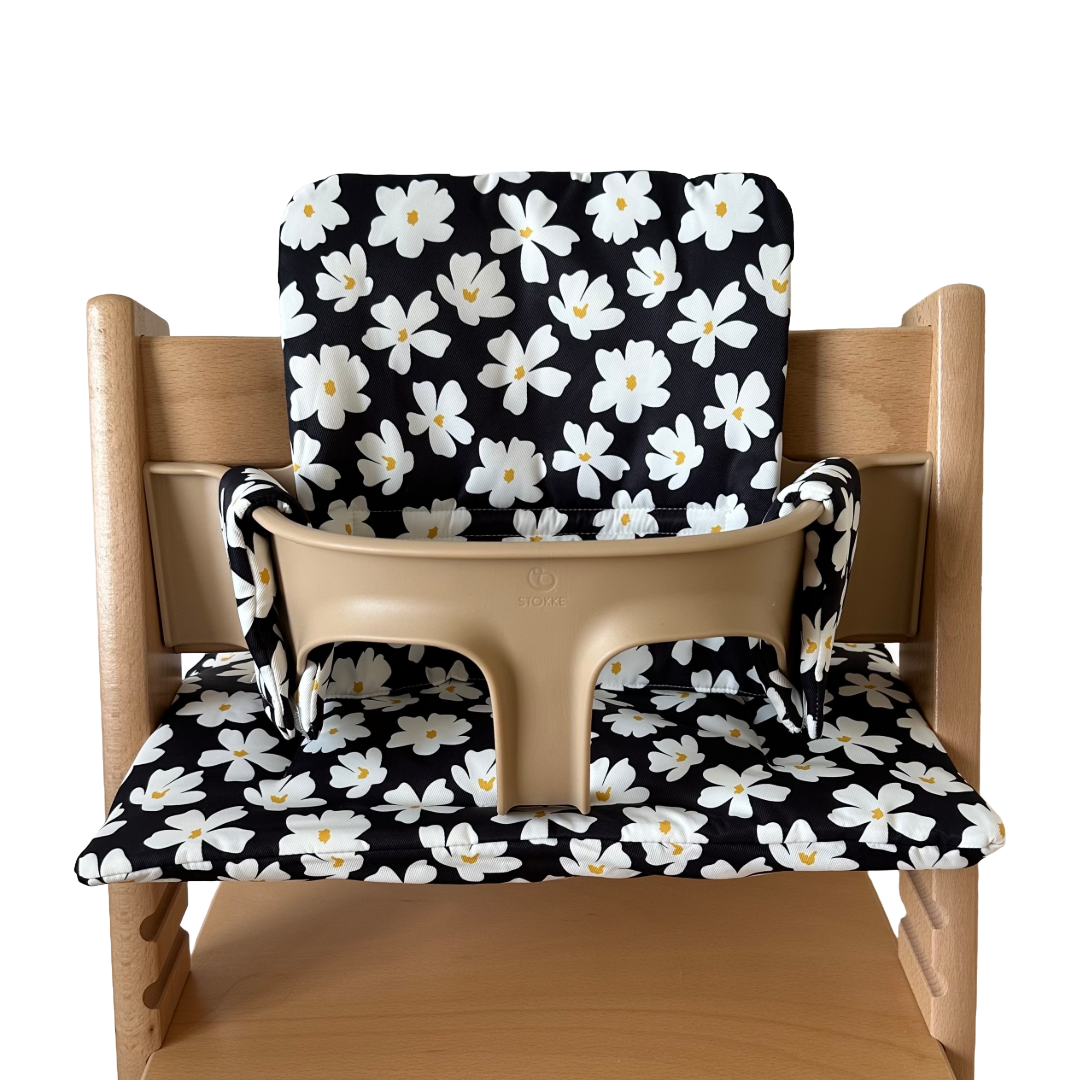 Kussenset voor Stokke Tripp Trapp met bloemenprint (zwart, wit). Vooraanzicht van het kussen op de stoel met gebruik van de babyset.