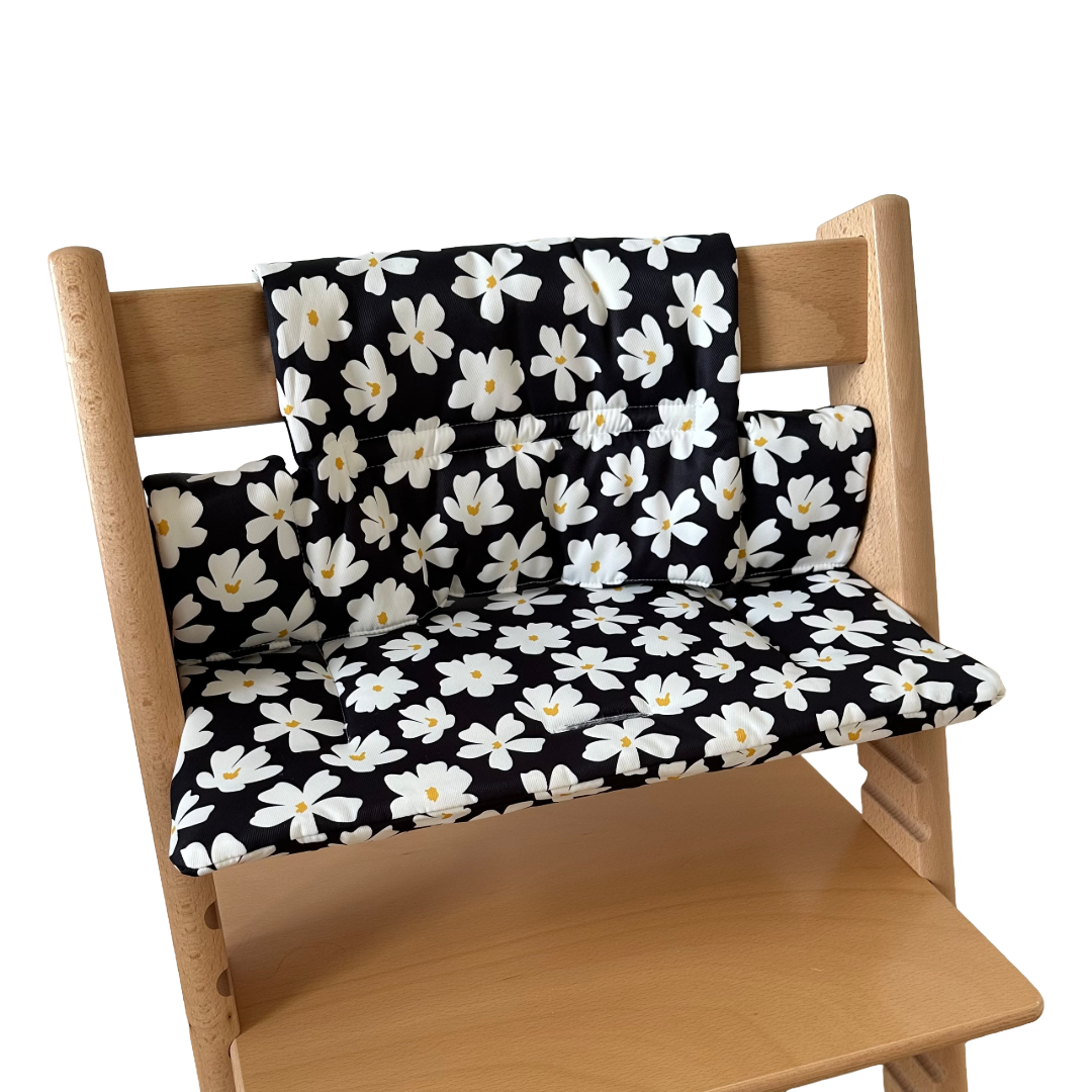Kussenset voor Stokke Tripp Trapp met bloemenprint (zwart, wit). Zijaanzicht van het kussen op de stoel zonder gebruik van de babyset.