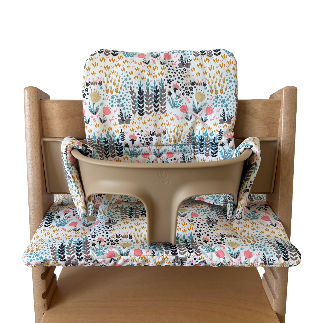 Kussenset voor Stokke Tripp Trapp met print bloemenweide (blauw). Vooraanzicht van het kussen op de stoel met gebruik van de babyset.