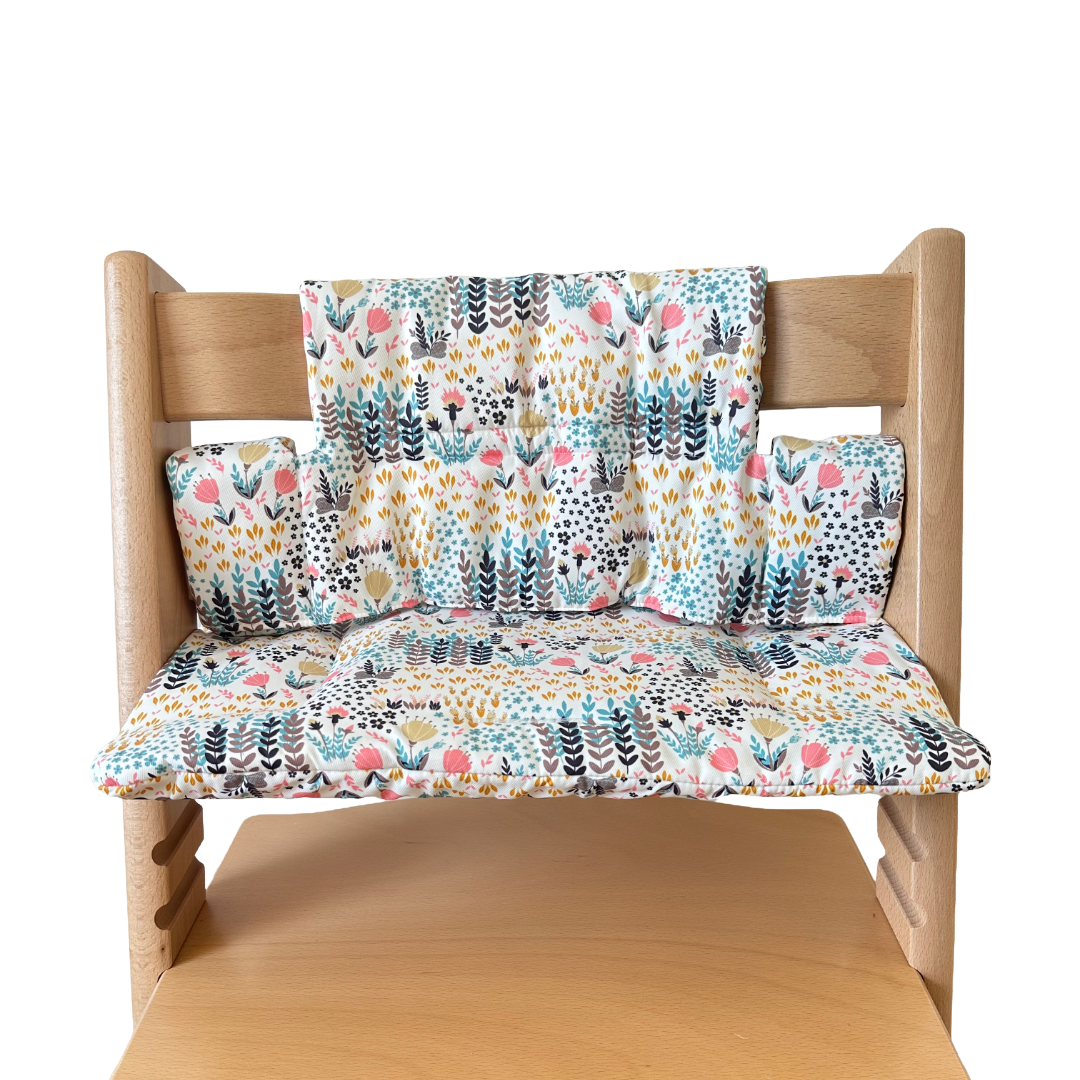 Kussenset voor Stokke Tripp Trapp met print bloemenweide (blauw). Vooraanzicht van het kussen op de stoel zonder gebruik van de babyset.