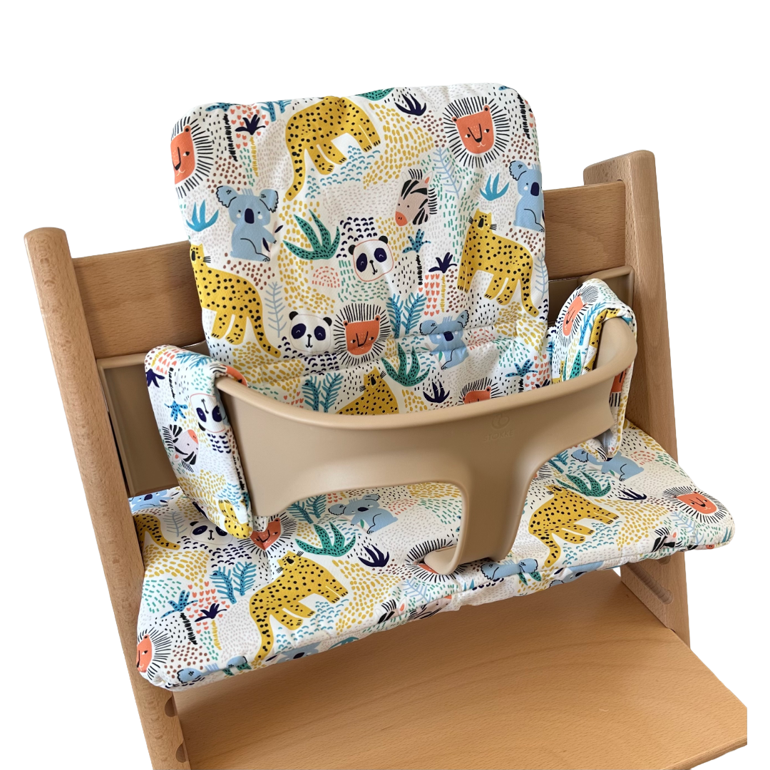 Kussenset voor Stokke Tripp Trapp met dierenprint (koala, panda, leeuw, tijger). Zijaanzicht van het kussen op de stoel met gebruik van de babyset.