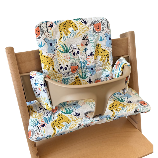 Kussenset voor Stokke Tripp Trapp met dierenprint (koala, panda, leeuw, tijger). Zijaanzicht van het kussen op de stoel met gebruik van de babyset.