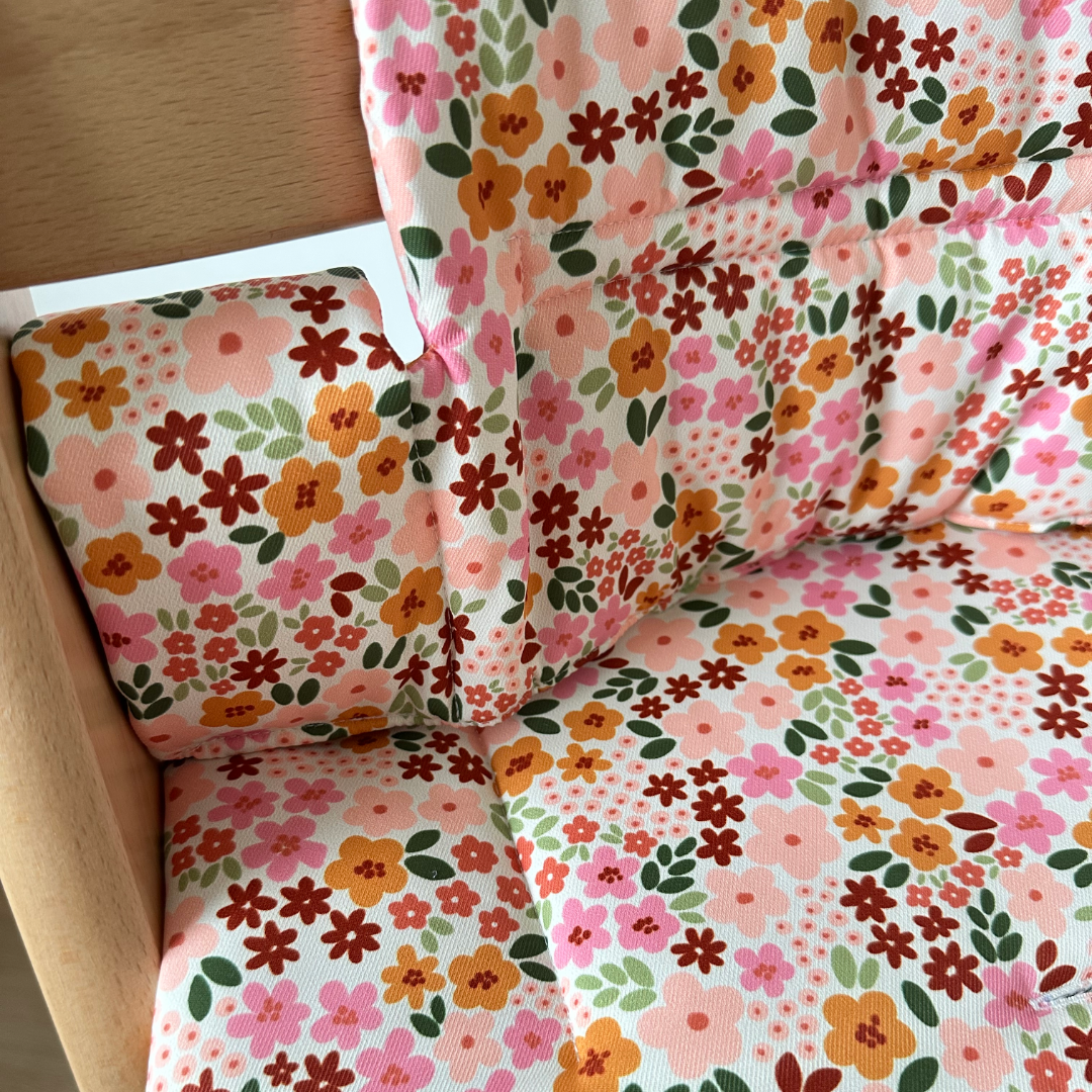 Kussenset voor Stokke Tripp Trapp met herfstbloemen (oranje, rood, roze). Close up van het kussen op de stoel zonder gebruik van de babyset.