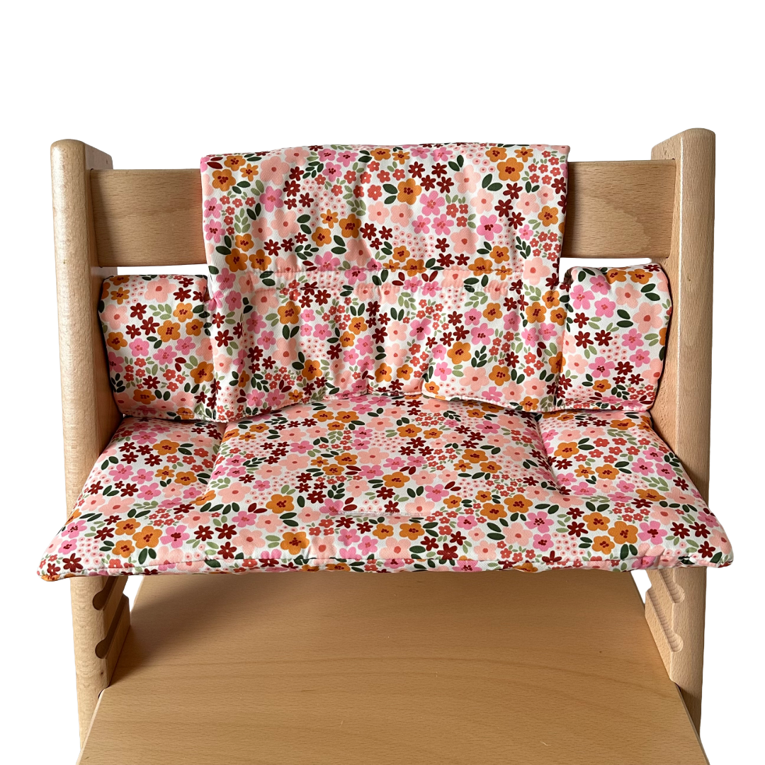 Kussenset voor Stokke Tripp Trapp met herfstbloemen (oranje, rood, roze). Vooraanzicht van het kussen op de stoel zonder gebruik van de babyset.