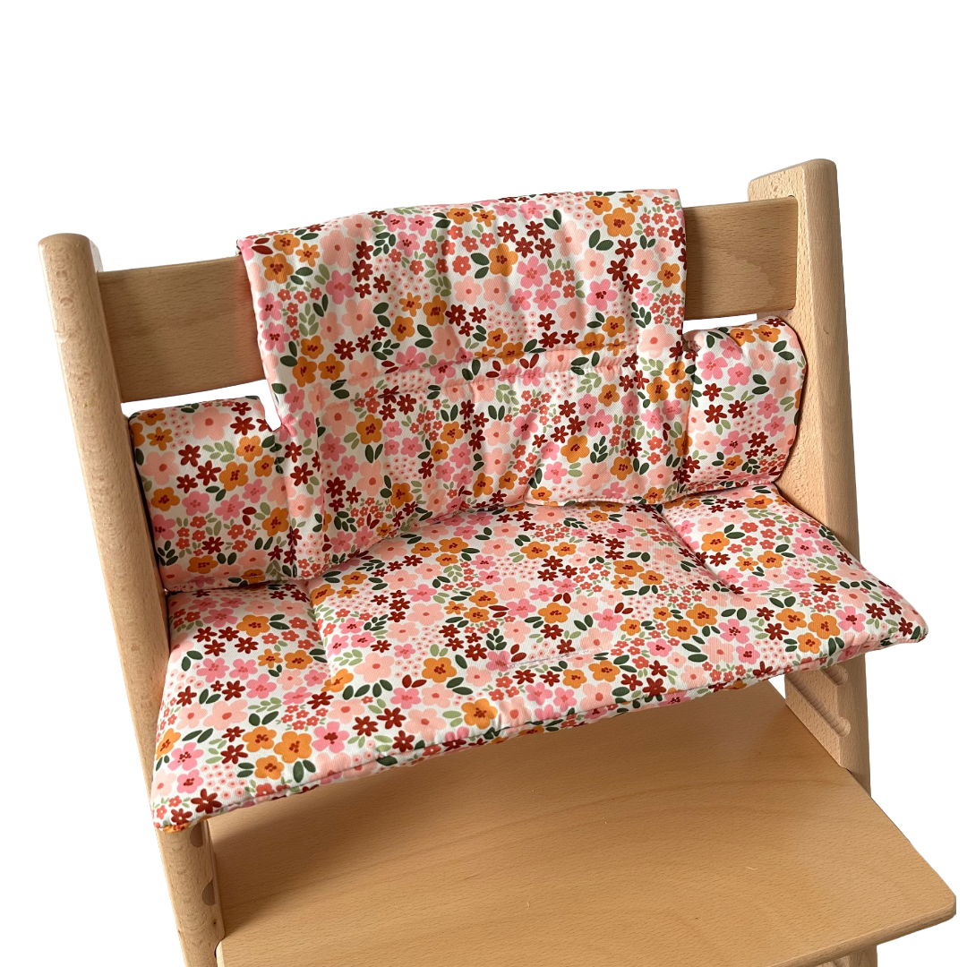 Kussenset voor Stokke Tripp Trapp met herfstbloemen (oranje, rood, roze). Zijaanzicht van het kussen op de stoel zonder gebruik van de babyset.