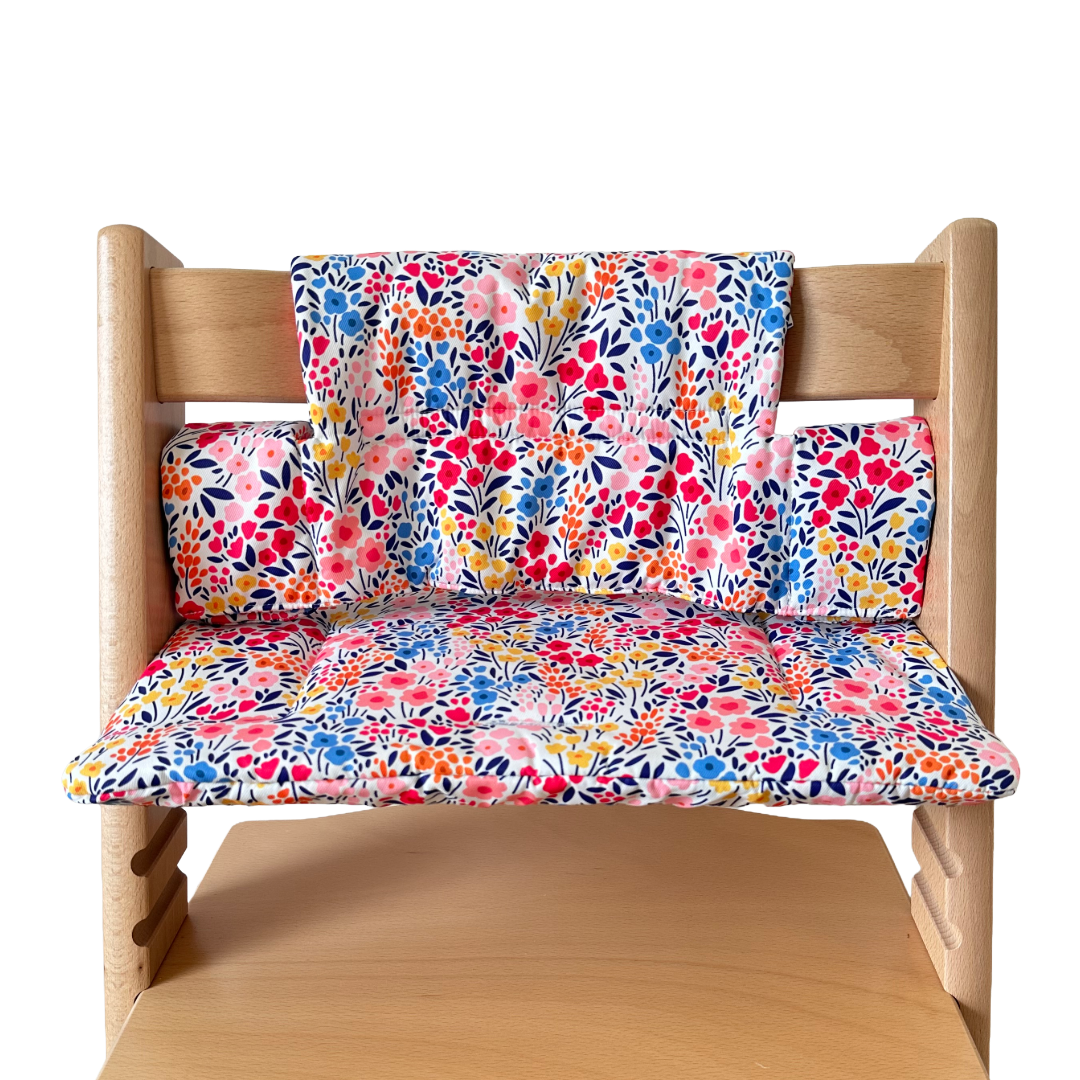 Kussenset voor Stokke Tripp Trapp met kleurrijke bloemen. Vooraanzicht van het kussen op de stoel zonder gebruik van de babyset.