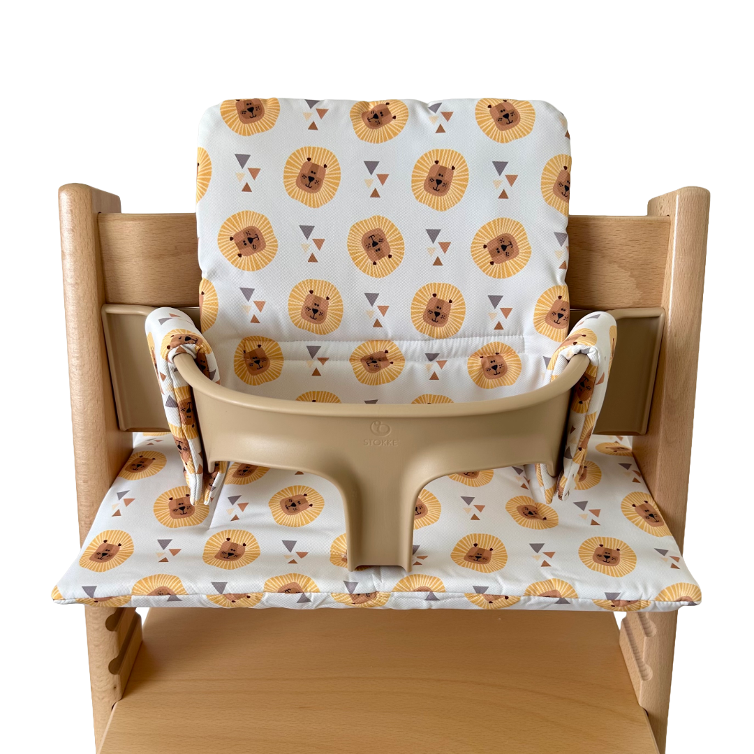 Kussenset voor Stokke Tripp Trapp met leeuwen print. Vooraanzicht van het kussen op de stoel met gebruik van de babyset.