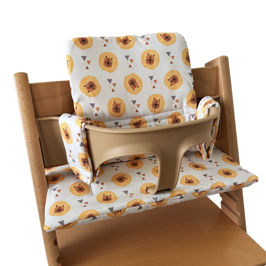Kussenset voor Stokke Tripp Trapp met leeuwen print. Zijaanzicht van het kussen op de stoel met gebruik van de babyset.