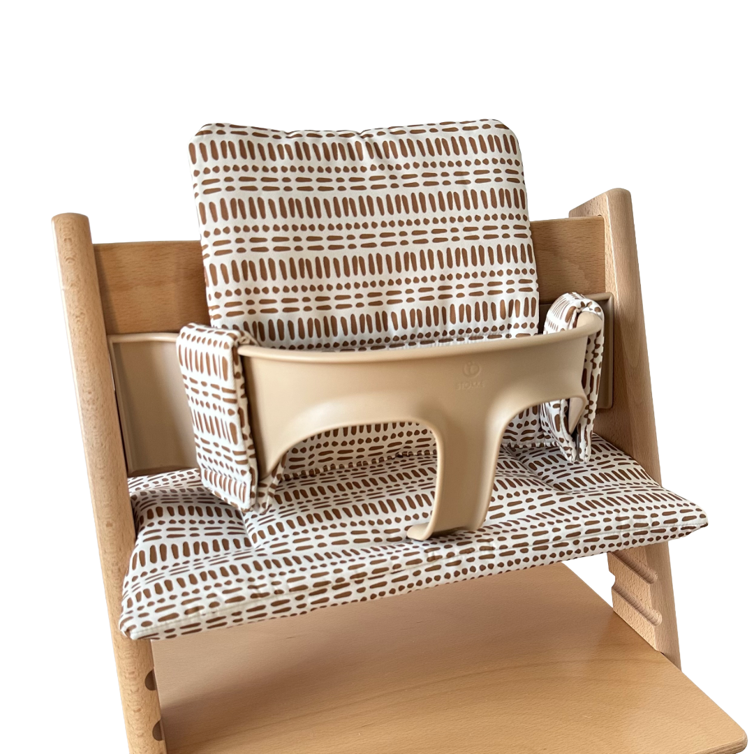 Kussenset voor Stokke Tripp Trapp met nordic grid patroon. Zijaanzicht van het kussen op de stoel met gebruik van de babyset.