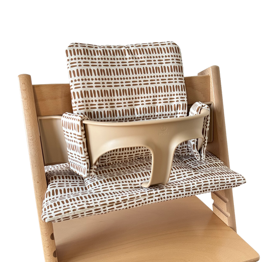 Kussenset voor Stokke Tripp Trapp met nordic grid patroon. Zijaanzicht van het kussen op de stoel met gebruik van de babyset.