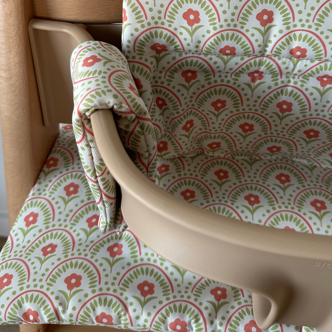 Kussenset voor Stokke Tripp Trapp met retro bloemenprint. Close up van het kussen op de stoel met gebruik van de babyset.