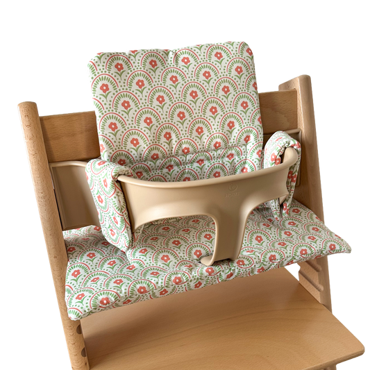 Kussenset voor Stokke Tripp Trapp met retro bloemenprint. Zijaanzicht van het kussen op de stoel met gebruik van de babyset.