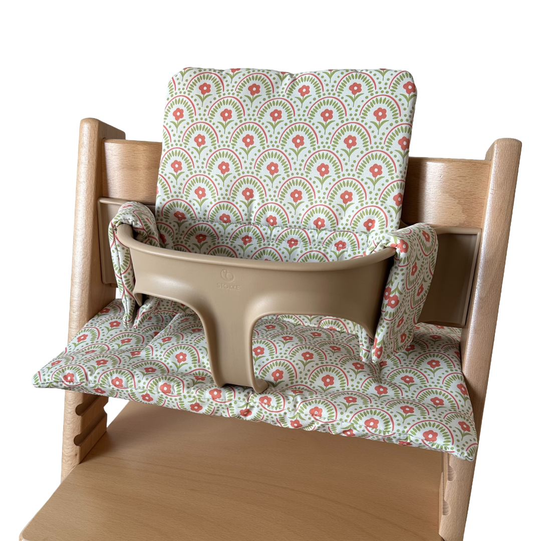 Kussenset voor Stokke Tripp Trapp met retro bloemenprint. Zijaanzicht van het kussen op de stoel met gebruik van de babyset.