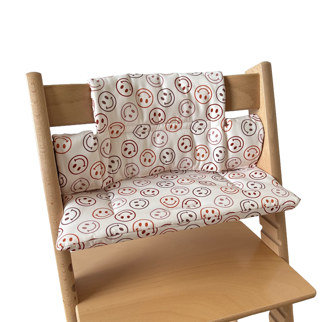 Kussenset voor Stokke Tripp Trapp met smileys patroon. Zijaanzicht van het kussen op de stoel zonder gebruik van de babyset.