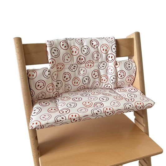 Kussenset voor Stokke Tripp Trapp met smileys patroon. Zijaanzicht van het kussen op de stoel zonder gebruik van de babyset.