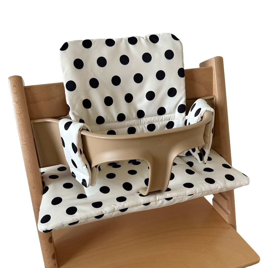 Kussenset voor Stokke Tripp Trapp met stippen (zwart, wit). Zijaanzicht van het kussen op de stoel met gebruik van de babyset.