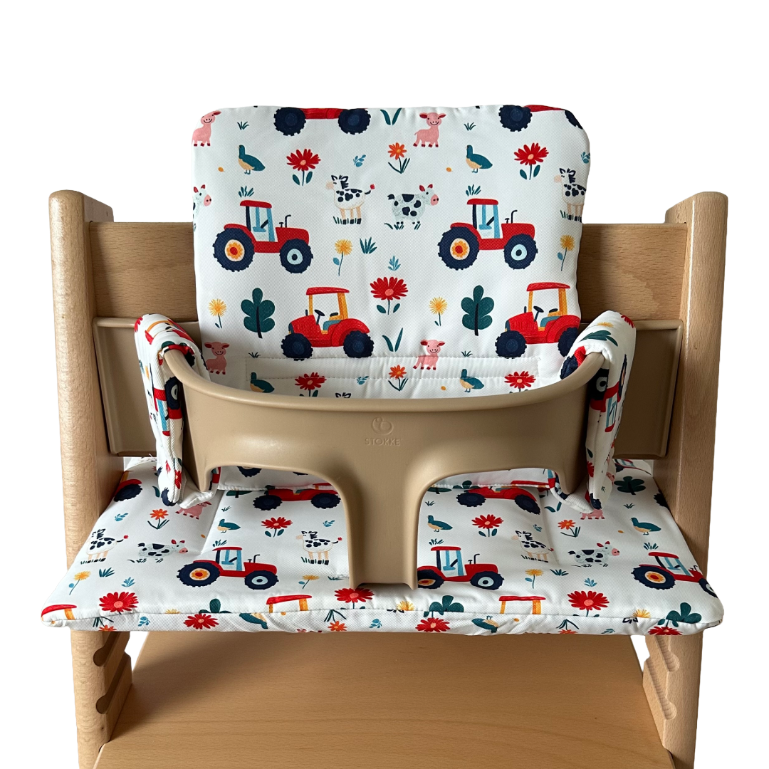Kussenset voor Stokke Tripp Trapp met tractor print. Vooraanzicht van het kussen op de stoel met gebruik van de babyset.