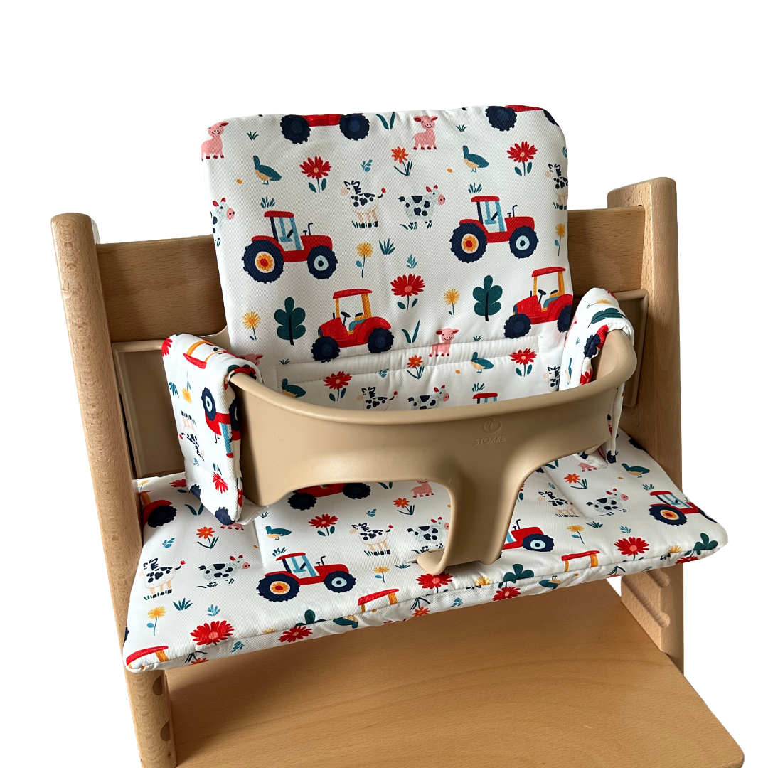 Kussenset voor Stokke Tripp Trapp met tractor print. Zijaanzicht van het kussen op de stoel met gebruik van de babyset.