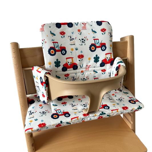 Kussenset voor Stokke Tripp Trapp met tractor print. Zijaanzicht van het kussen op de stoel met gebruik van de babyset.